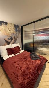 a bedroom with a large bed with a red blanket at Apartament Centrum Ligota in Katowice