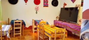 a room with a tv and a table and chairs at Jardín Andino Hostal in Copacabana