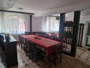 a dining room with a red table and chairs at Casa Ursilor in Predeal