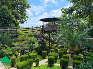 ein Garten mit einem Aussichtsturm in der Mitte in der Unterkunft Garden Hotel in Kutaissi