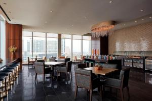 a dining room with tables and chairs and windows at Marriott Marquis Houston in Houston