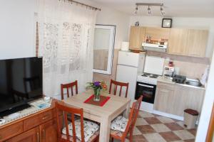 a kitchen with a table with chairs and a television at Bellora Studio House in Donja Jošica