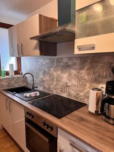a kitchen with a sink and a stove top oven at Ferienhaus Fehmarnliebe in Fehmarn