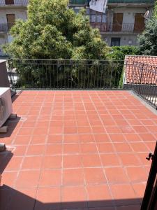 a red tile floor on a balcony with a fence at la dimora del centro in Zafferana Etnea