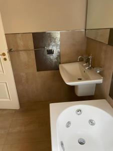 a bathroom with a sink and a toilet and a sink at la dimora del centro in Zafferana Etnea +3 photos