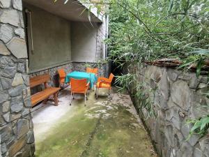 a patio with a table and chairs and a stone wall at Casa Ursilor in Predeal