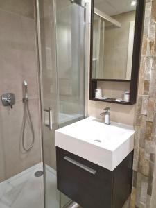 a bathroom with a white sink and a shower at Hotel Schtak in Cannes