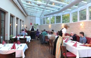 un grupo de personas sentadas en mesas en un restaurante en Landhotel Gasthof Krone, en Kupferzell