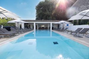 a large swimming pool with chairs and umbrellas at Royal Mougins Golf, Hotel & Spa de Luxe in Mougins