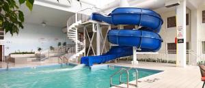 a blue water slide in a swimming pool at Viscount Gort Hotel, Banquet & Conference Centre in Winnipeg