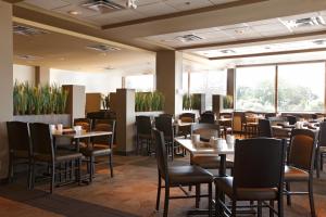 a restaurant with tables and chairs and windows at Viscount Gort Hotel, Banquet & Conference Centre in Winnipeg