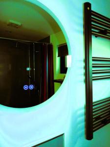 a bathroom with a round mirror and a shower at An Garraí Mór in Omagh