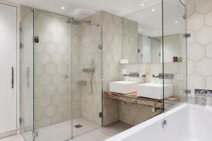 a bathroom with two sinks and a glass shower at VISIONAPARTMENTS Berlin - self check-in in Berlin