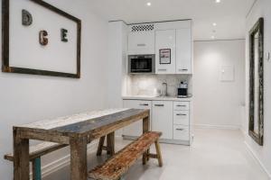 a kitchen with a wooden table and a bench at VISIONAPARTMENTS Berlin - self check-in in Berlin +50 photos