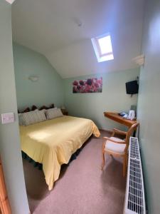 a bedroom with a bed and a desk and a window at Willow Tree Cottages in Newark-on-Trent
