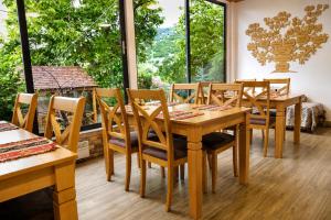 a dining room with wooden tables and chairs and large windows at Madin Eco Hotel in Debed