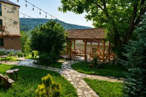 a gazebo in a garden next to a building at Madin Eco Hotel in Debed