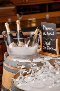 a bottle of champagne in a bucket on a barrel with wine glasses at Hotel Narcisa in Veržej