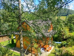 an orange house in the middle of a yard at Brzozowy Zakątek -Chatka Stokrotka in Krynica Zdrój