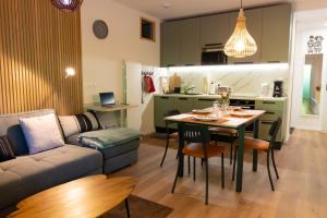 a living room and kitchen with a table and a couch at Cocon d'Altitude avec Terrasse, Calme & Parking Privé in Orbey