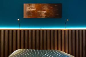 a bedroom with a bed and two lights on a wall at Cocon d'Altitude avec Terrasse, Calme & Parking Privé in Orbey