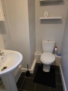 a bathroom with a white toilet and a sink at Near recreation park in Colchester