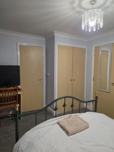 a bedroom with a bed and a chandelier at Near recreation park in Colchester