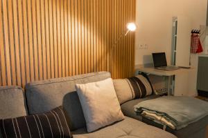 a living room with a couch and a desk with a laptop at Cocon d'Altitude avec Terrasse, Calme & Parking Privé in Orbey