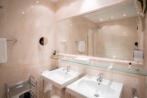 a bathroom with two sinks and a large mirror at Hotel König von Ungarn in Vienna +59 photos