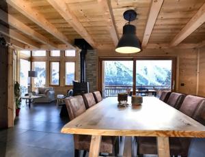 a dining room with a large wooden table and chairs at Chalet Loan in Montgenèvre