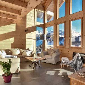 a living room with couches and a table at Chalet Loan in Montgenèvre
