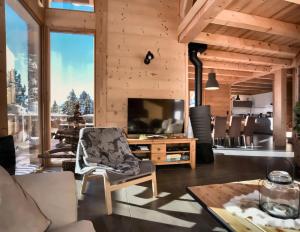 a living room with wooden walls and a television at Chalet Loan in Montgenèvre