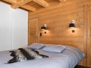 a bed in a room with a wooden wall at Chalet Loan in Montgenèvre