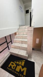 a staircase in a room with a rug on the floor at Flat - Para quem busca tranquilidade e conforto in Goiânia