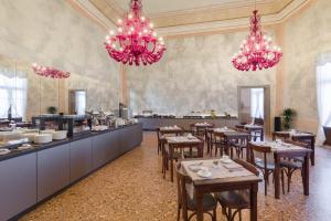 a restaurant with tables and pink chandeliers at Hotel Aquarius Venice - Ascend Collection in Venice