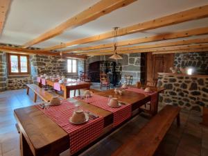 a dining room with wooden tables and a stone wall at La Maison de Julia in Blanzac