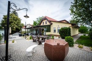 a patio with a table and a bench and a house at Diófa Vendégház in Békésszentandrás