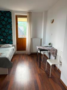 a room with a table and a bed and a window at Dzikie Fiołki in Karpacz