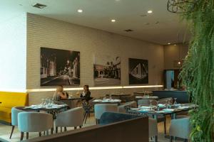 two people sitting at tables in a restaurant at Hotel Manantial Valencia in Valencia