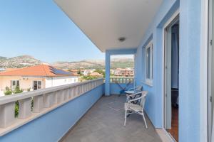a balcony with a chair on a blue house at Villa Ani in Trogir