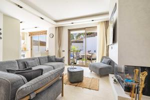 a living room with a gray couch and a fireplace at Villa Luna Bodrum, Özel Isıtmalı Havuzlu in Ortakent