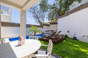 an outdoor patio with a table and a grill at Villa Luna Bodrum, Özel Isıtmalı Havuzlu in Ortakent