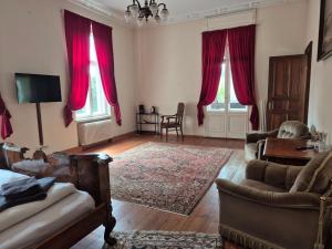 a living room with red curtains and a couch at PP Pension Potsdam in Potsdam +17 photos