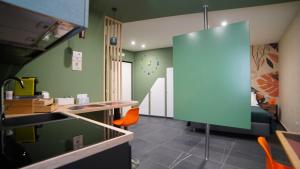 a kitchen with green walls and a sink and orange chairs at Didinas room in Potenza