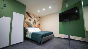 a bedroom with a bed and a flat screen tv at Didinas room in Potenza