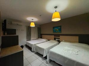 a hotel room with two beds and two lights at Hotel O Recanto in Campo Mourão +41 photos