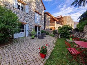 a patio with a table and chairs in front of a building at La Maison de Julia in Blanzac