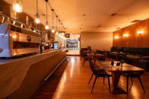 a restaurant with tables and chairs and a bar at Hotel Parada Linares in Linares