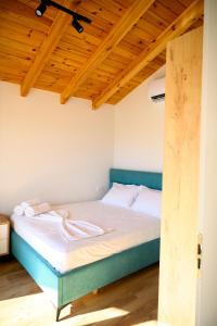a bed in a room with a wooden ceiling at Kompleksi Turistik ARMANDO in Tale