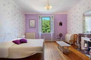 a purple bedroom with a bed and a fireplace at Domaine De La Perthuiserie in Saint-Porchaire